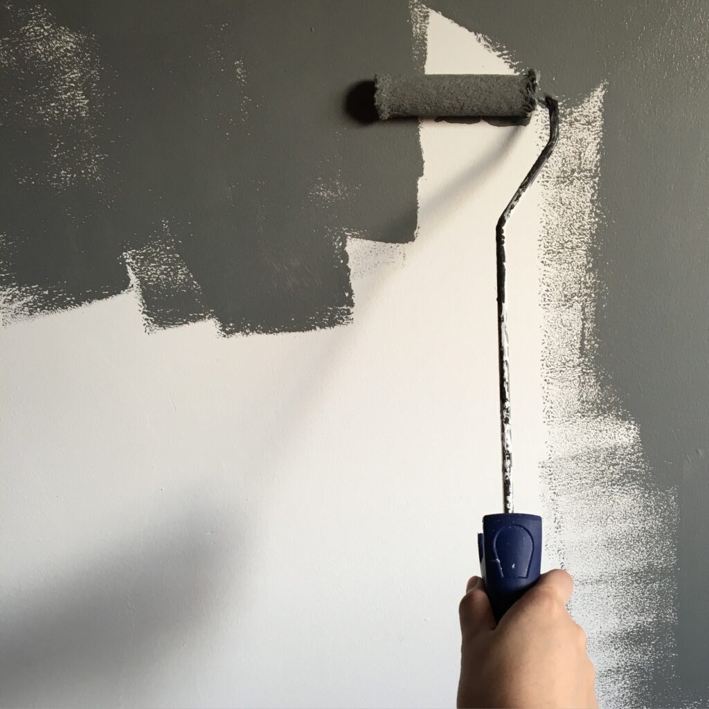 painting a wall with grey paint