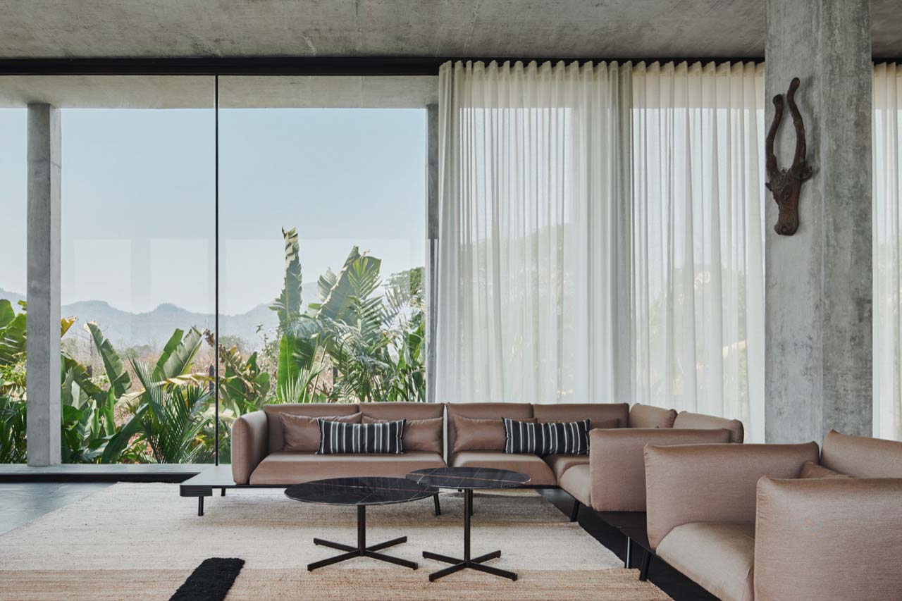 a farmhouse living room with furniture, full height windows and drapes