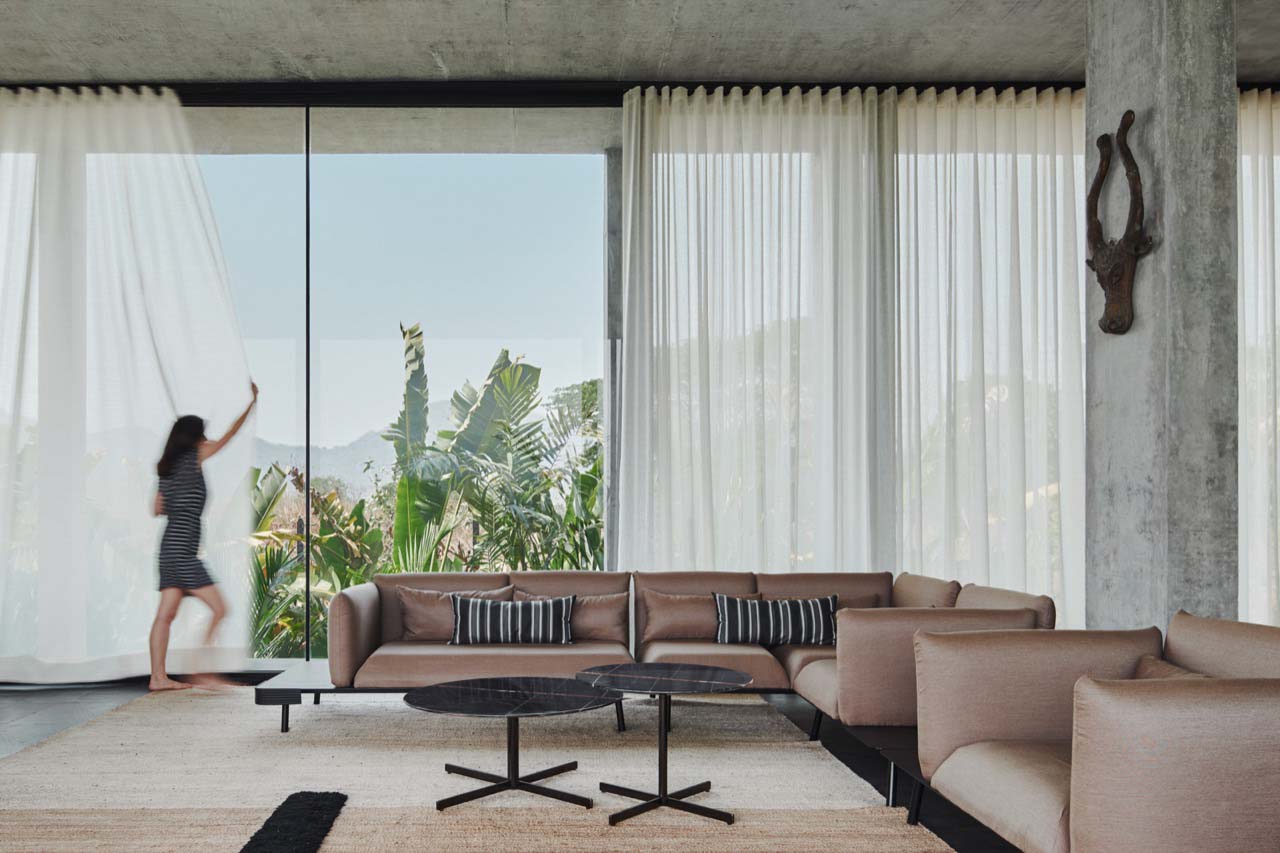 a farmhouse living room with furniture, full height windows and drapes