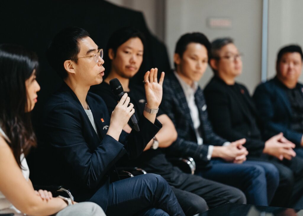 a group of people sitting and addressing a crowd