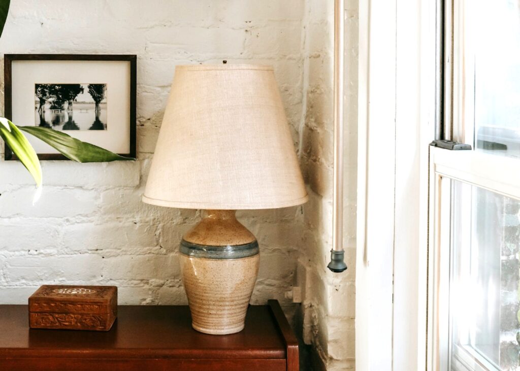 a side table with a lamp and other wood decor