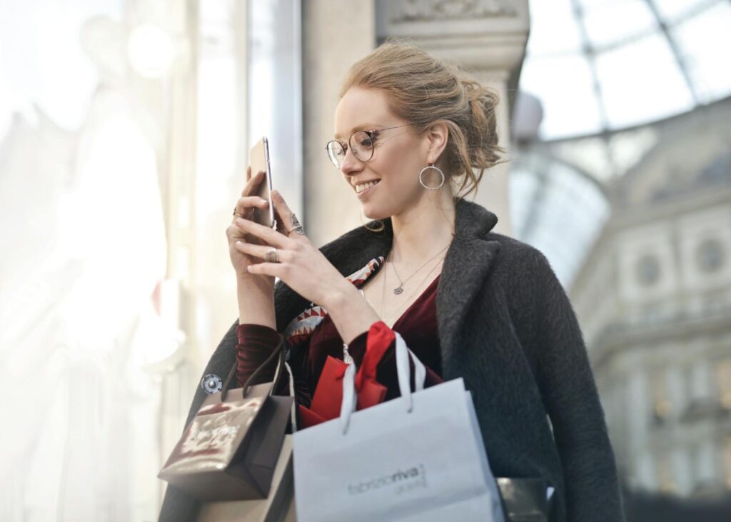 a girl shopping and surfing her mobile phone at the same time