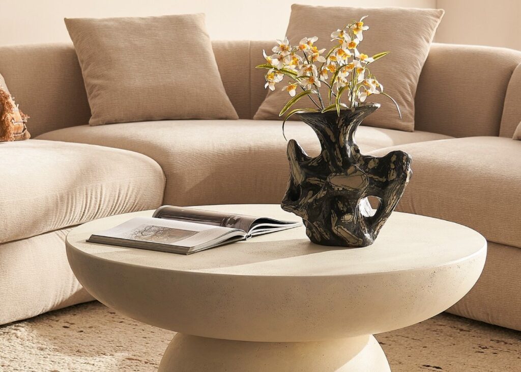 a coffee table with decor and a sofa behind