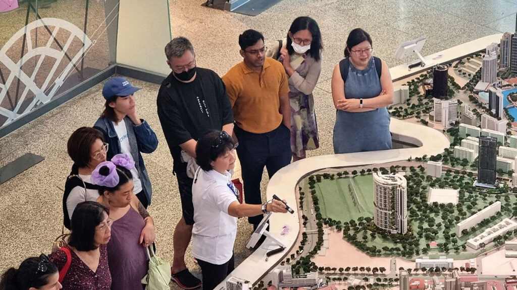 a group of people discussing around an architecture model