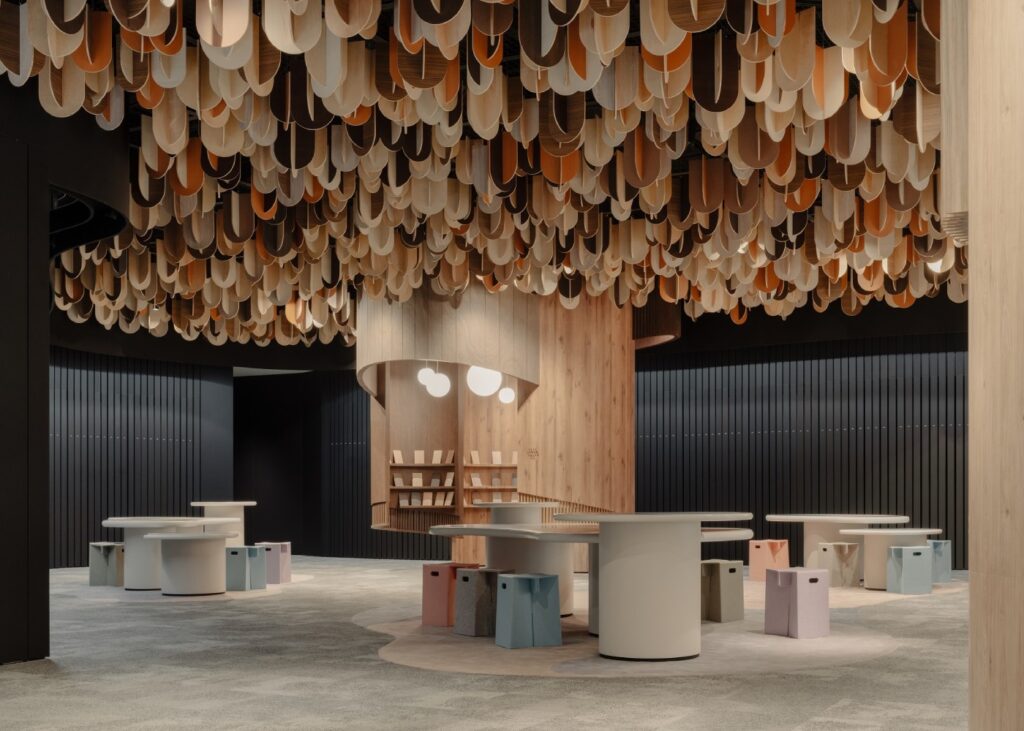 a laminate fishes library with a sculptural tree in the center with colorful tables around