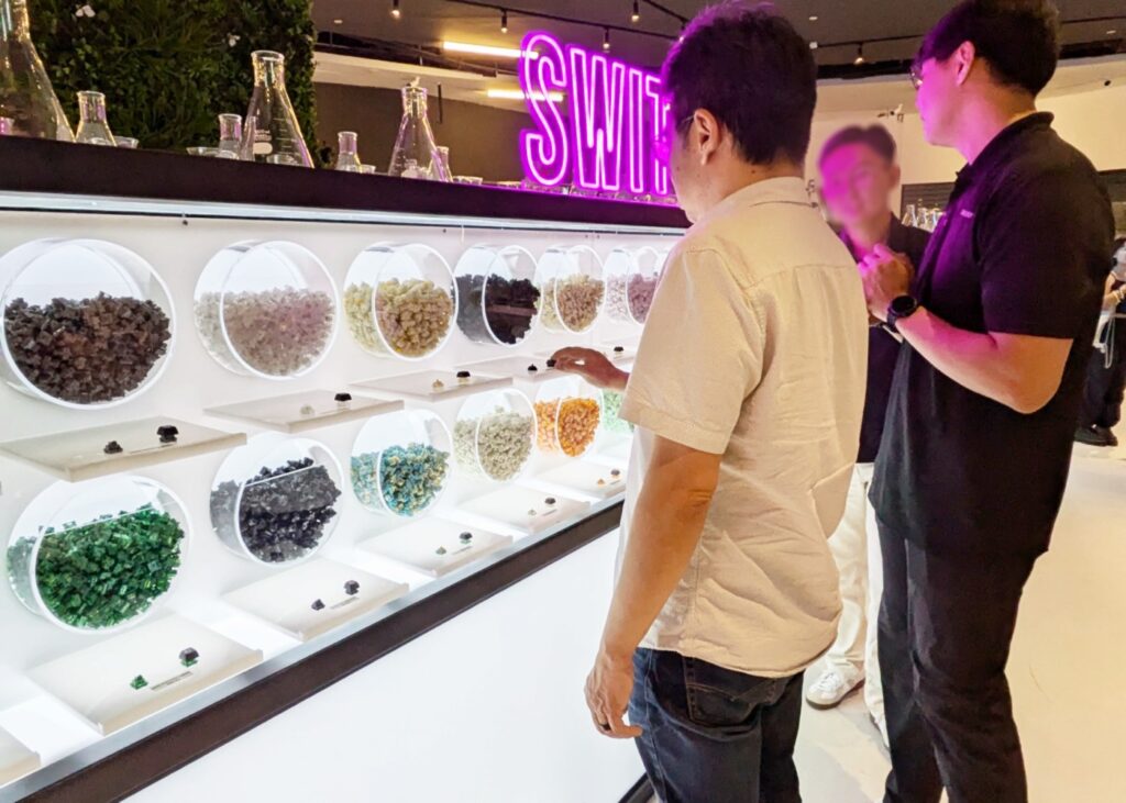 3 men looking at a display of keyboard parts at a showroom