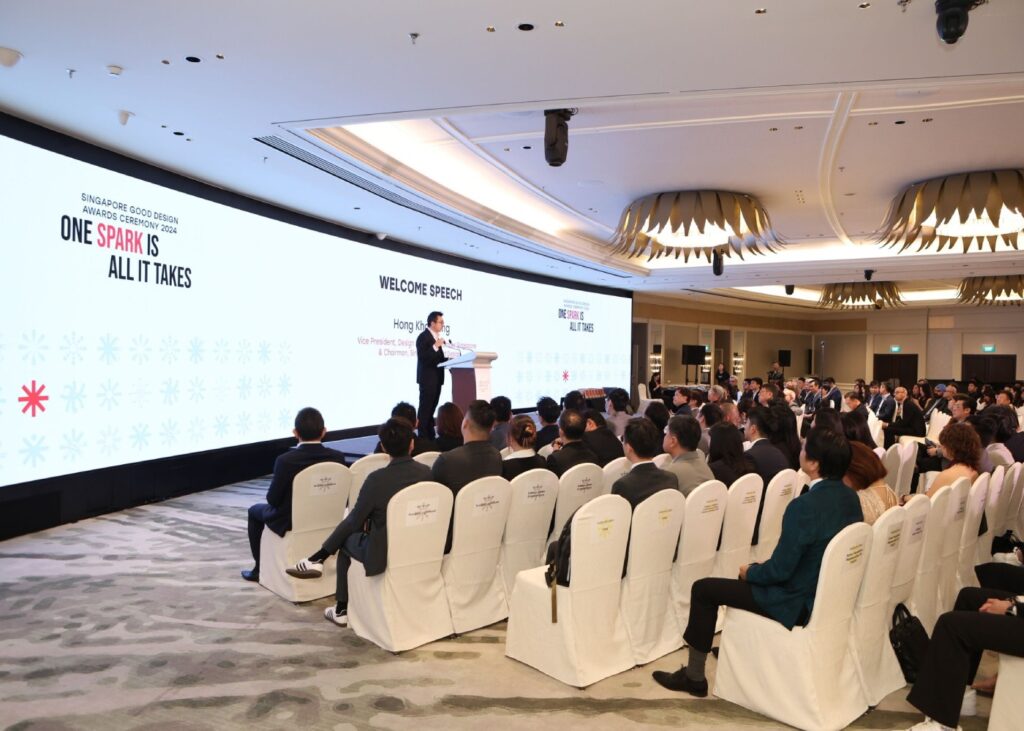 a conference hall filled with people watching a commencement speech