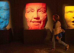 a boy walking by 3 lego sculptures