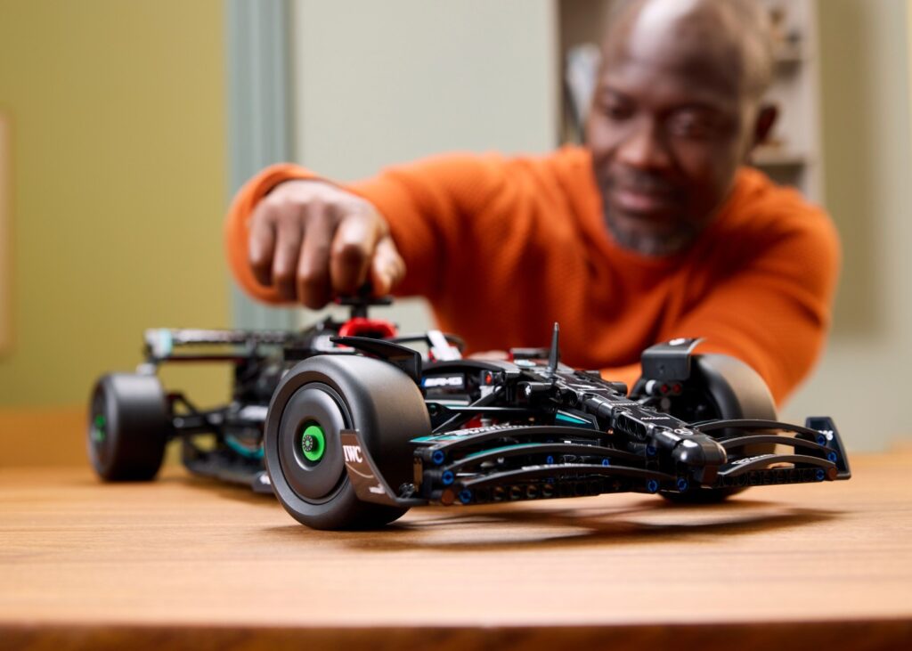 man building a lego car model