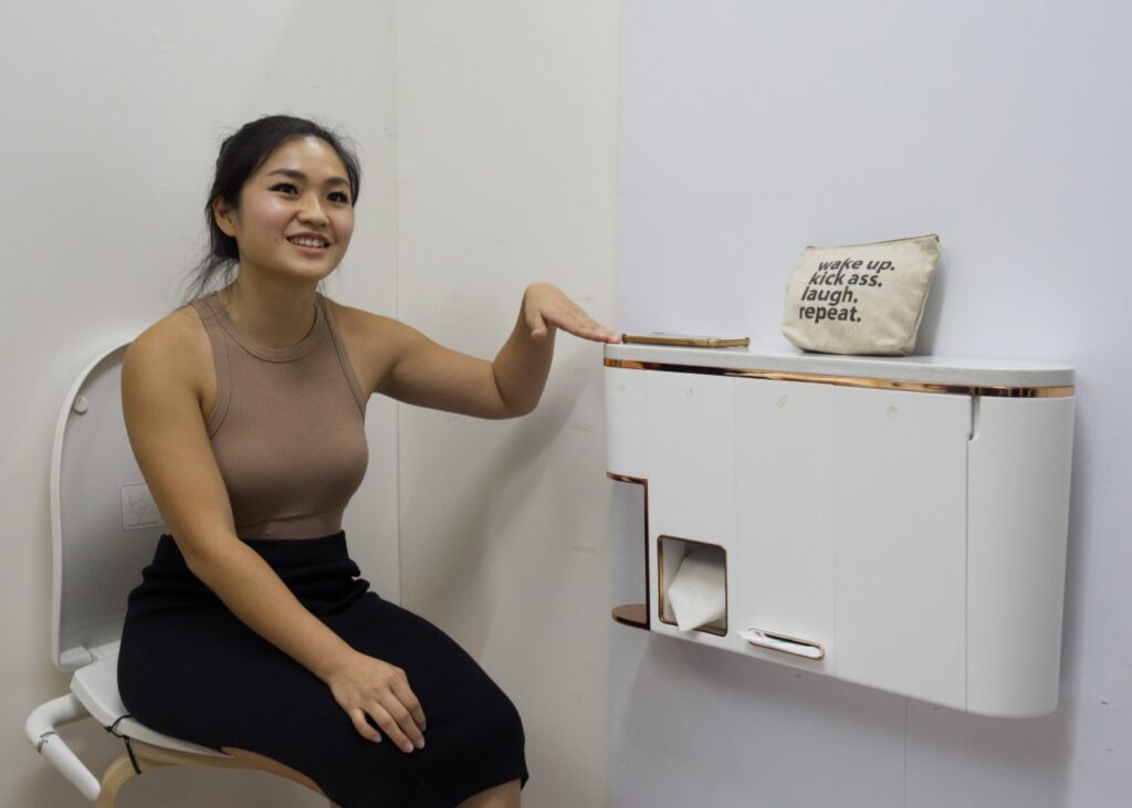 women user testing a gadget installed in a restroom